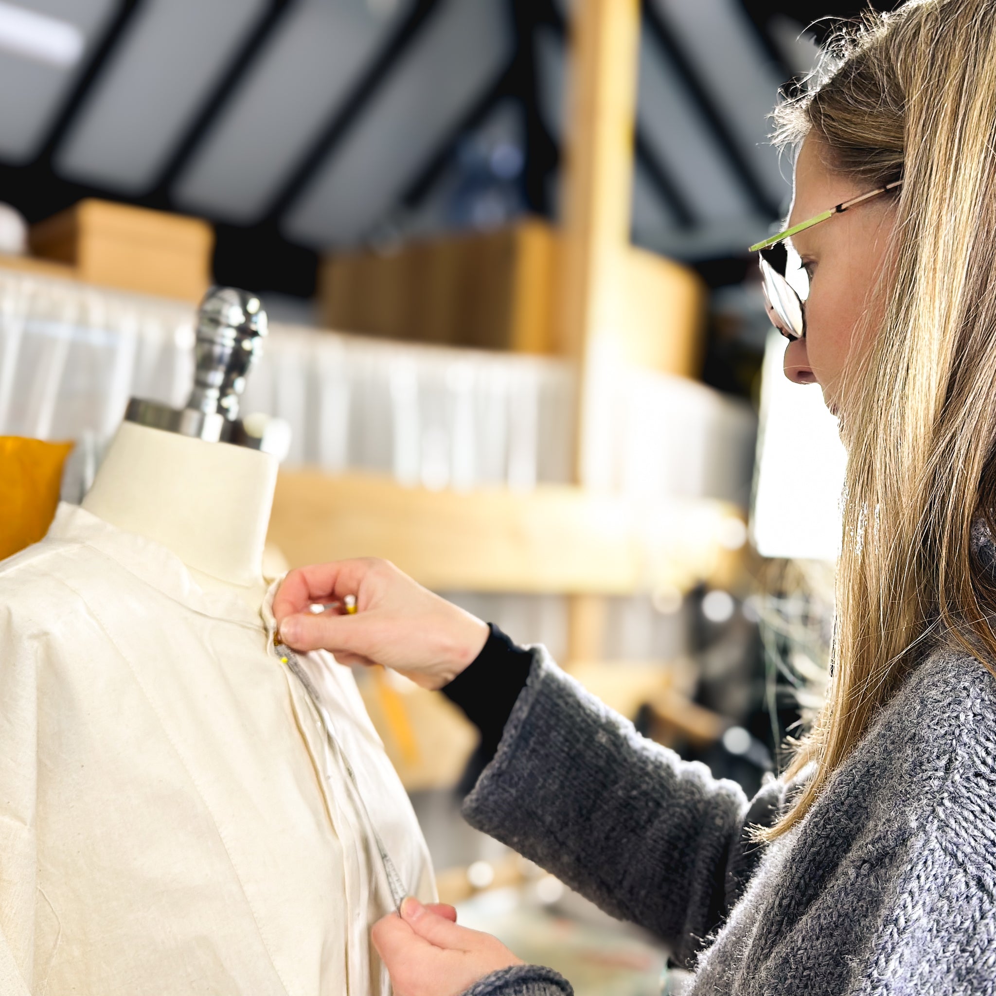 Pattern cutter measuring garment on mannequin